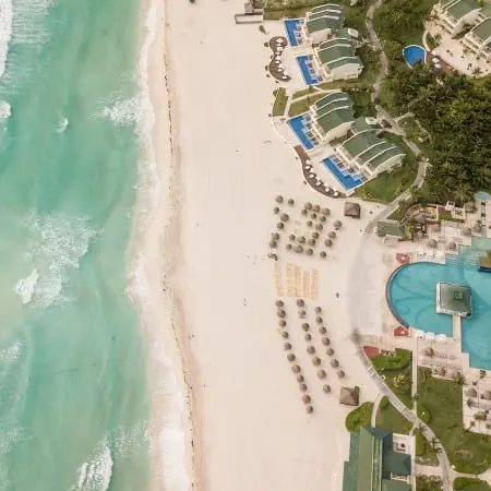 Aerial view of pristine beach with turquoise water and beachfront resort