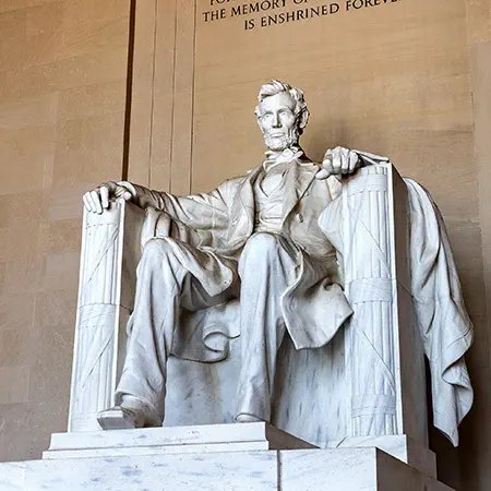Marble statue of seated figure in neoclassical style inside government building
